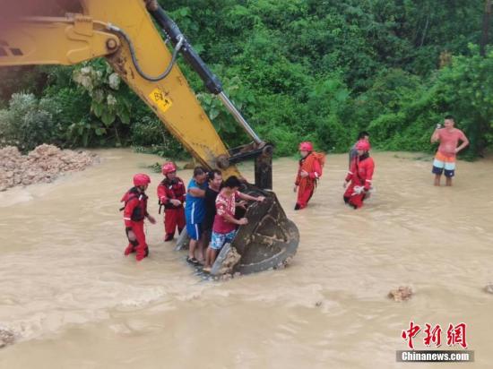 6月16日，因遭遇暴雨袭击，广西沿海多处发生严重内涝，居民被困。当地消防部门接到求助信息后，先后转移被困的居民数十人。图为利用铲车运送被困居民。